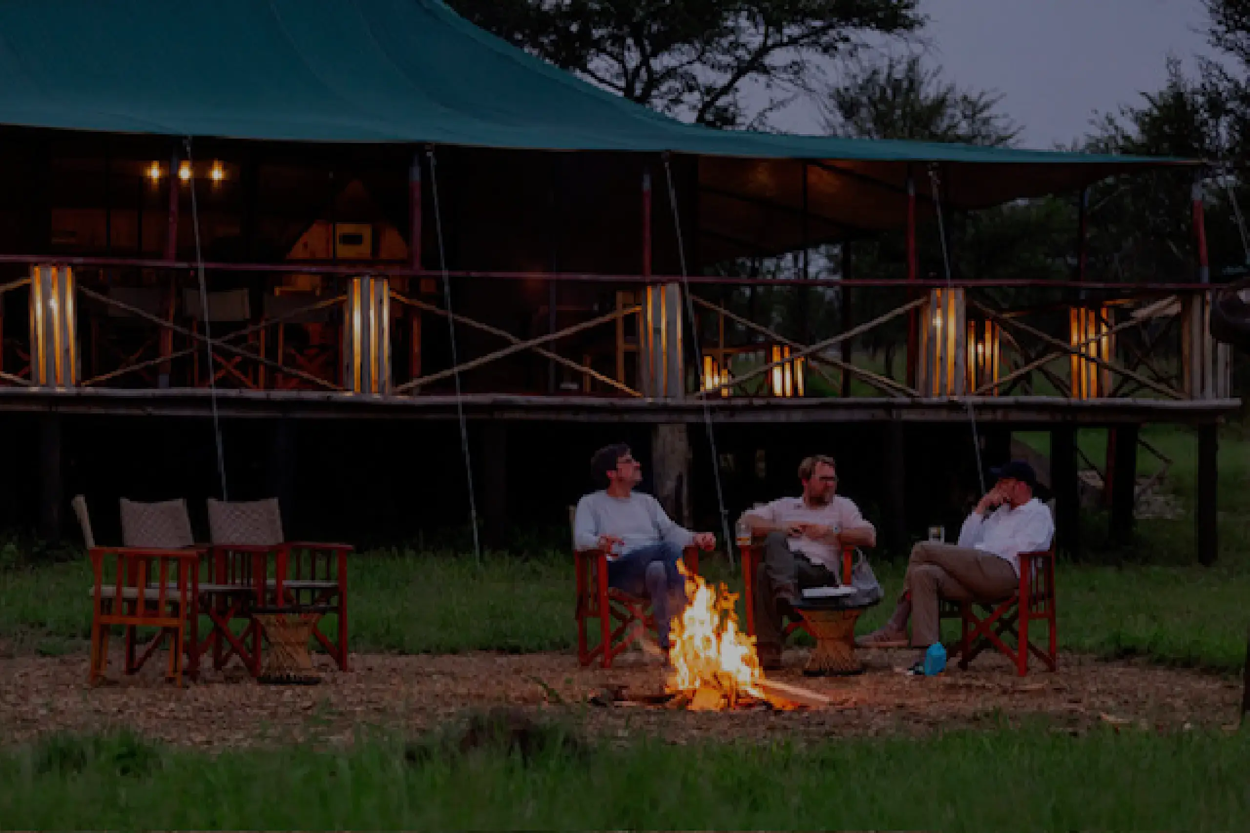A group of tourists gathering at the campfire Moyo tneted camp