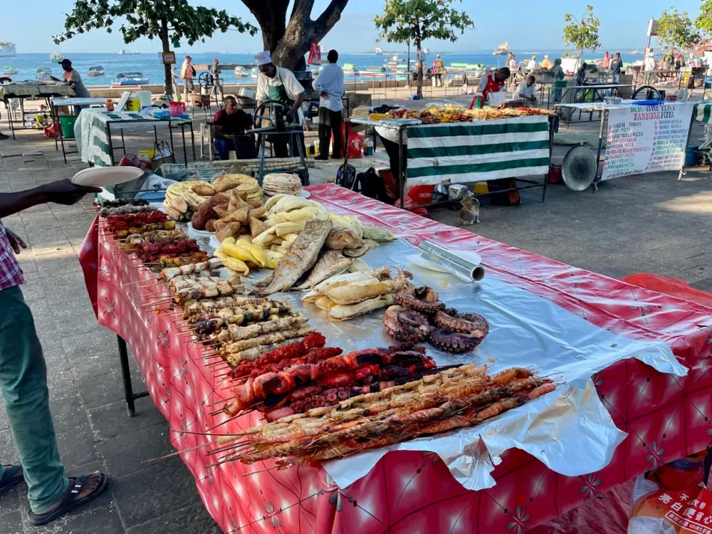 27 Things to Do in Zanzibar (2026 Must‑See List) 17 Tourists enjoying authentic Zanzibari food at local restaurants and street stalls, beyond hotel buffets