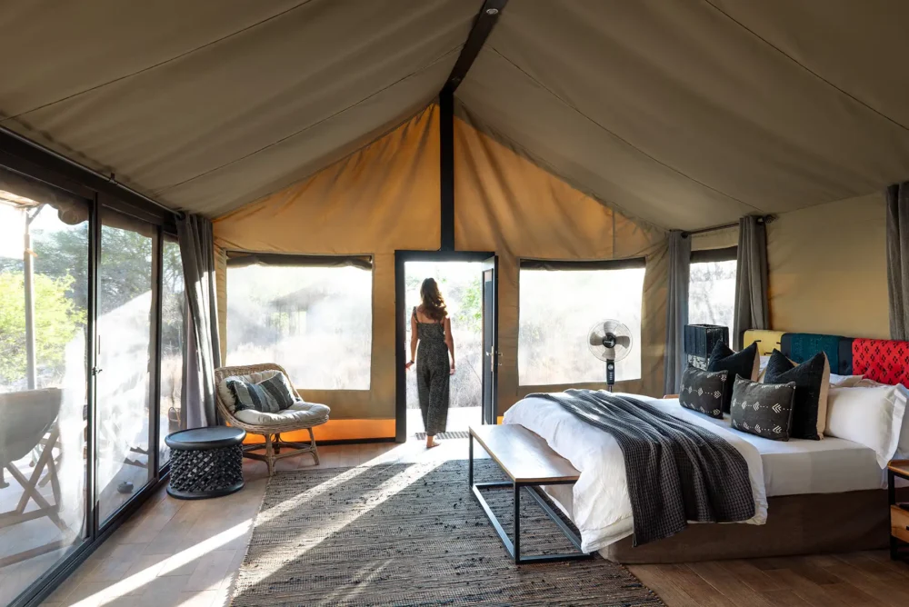 Interior of a luxury tented camp room in the Serengeti featuring a comfortable bed, elegant décor, and safari-style design.