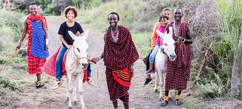 Maasai Morani walking with a donkey in West Kilimanjaro, Tanzania, showing the traditional lifestyle and culture of the Maasai community.